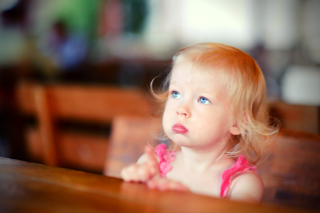 image of a small girl looking up with her mouth closed because she's been told children should be seen and not heard